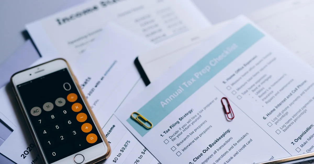 A phone calculator app lying on printed accounting documents