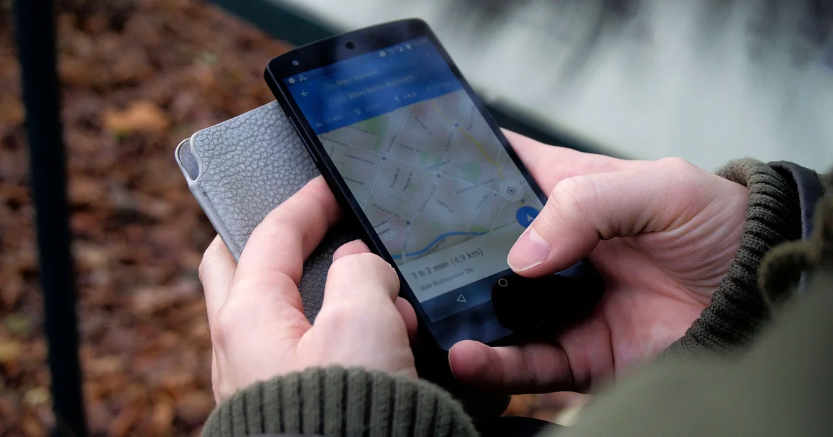 Two hands holding a smartphone with Google Maps directions open